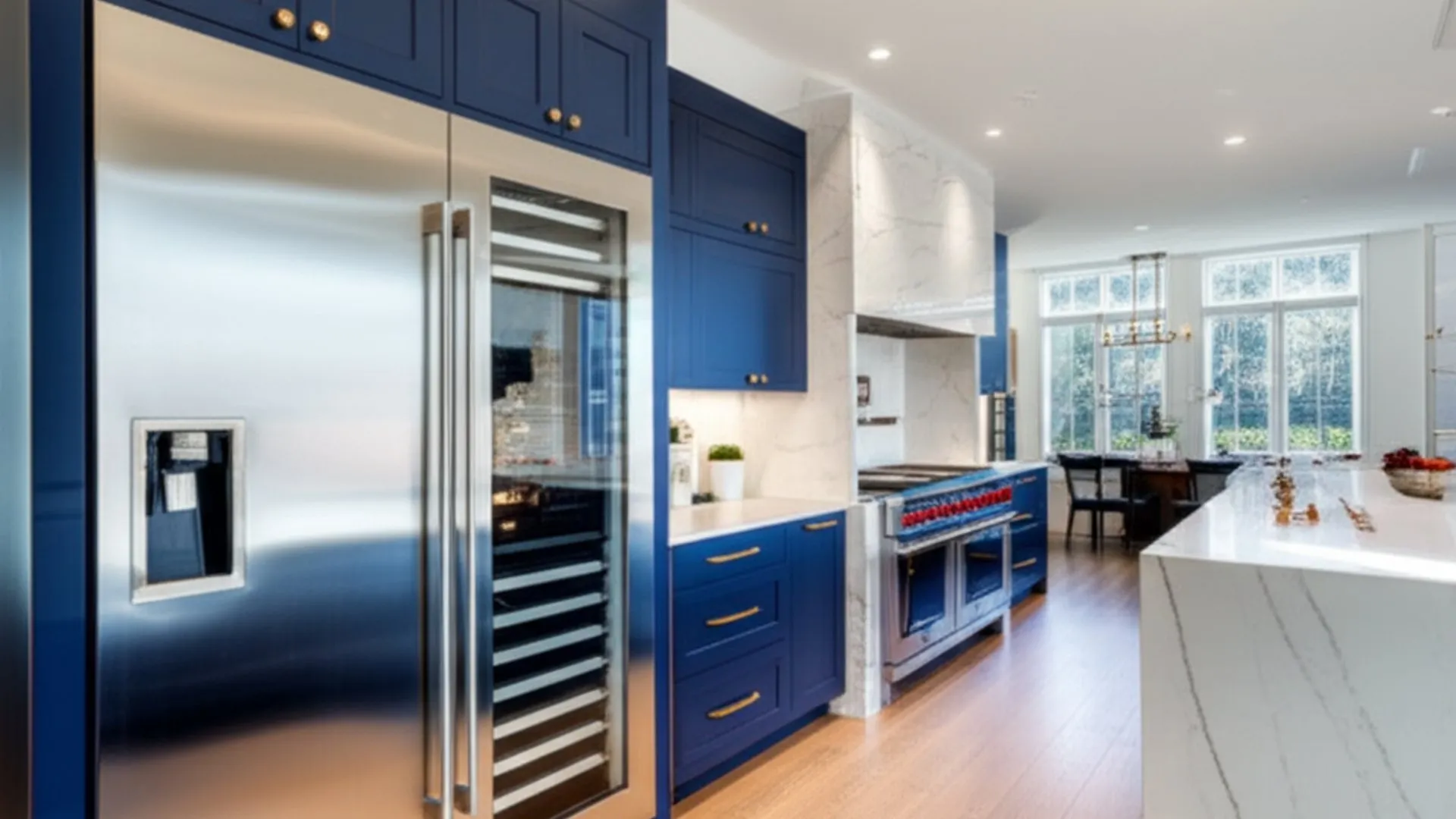 Navy-blue kitchen cabinetry with a full-height stainless refrigerator and dispenser panel, the room opening out behind it